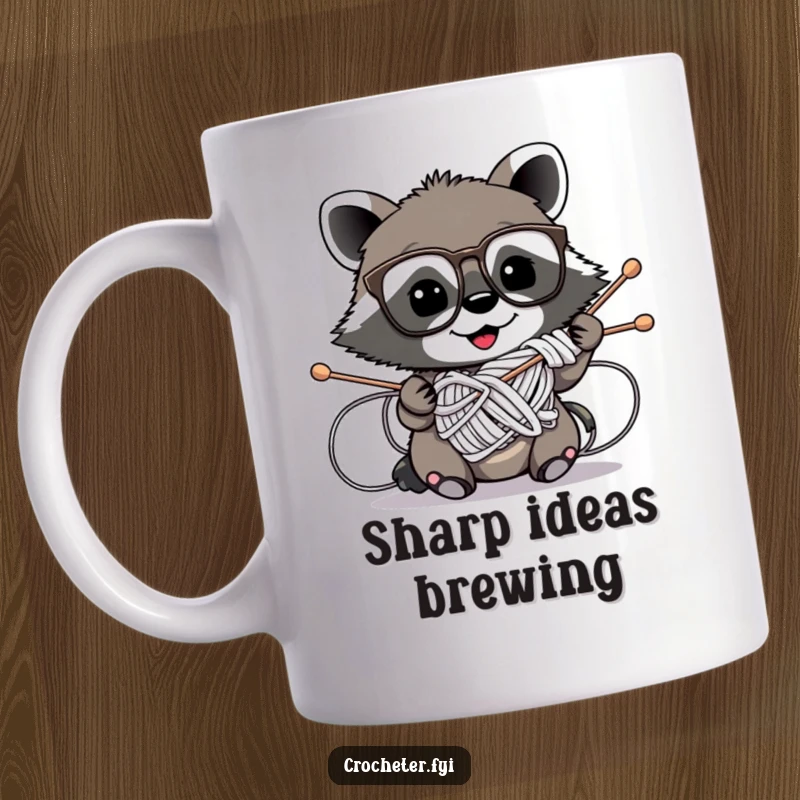 Funny mug showing a mischievous raccoon wearing glasses hilariously tangled in knitting needles, a chaotic crafting scene.