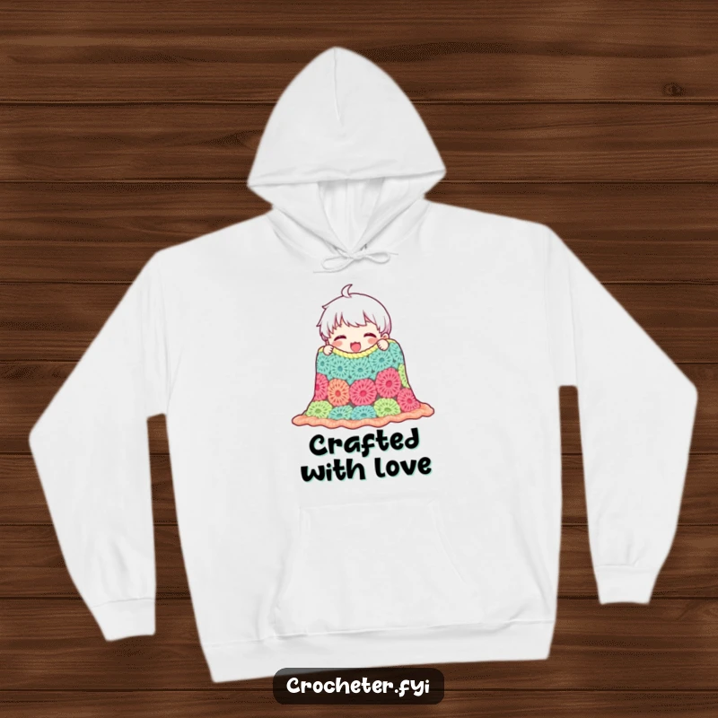 Funny hoodie featuring a content character proudly admiring a handmade crocheted blanket, offering cozy warmth and celebrating the art of crafting.
