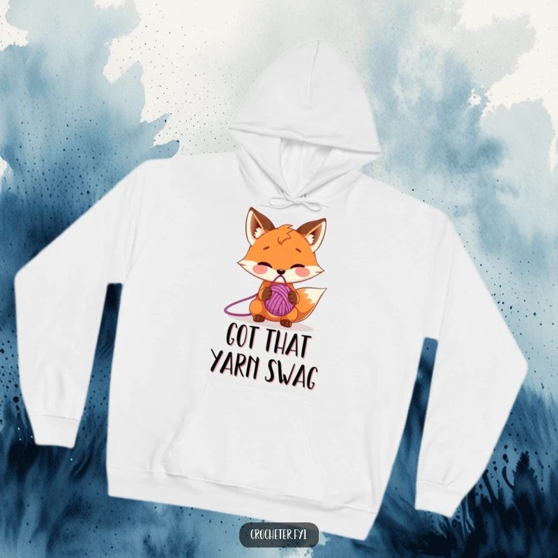 Funny hoodie displaying a sly fox character balancing a ball of yarn on its nose, demonstrating playful skill and charm.