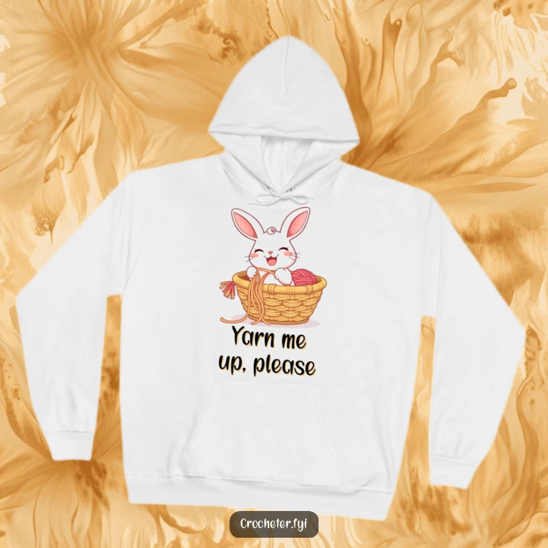 Funny hoodie displaying a cheerful rabbit with a big grin, pulling a long string of colorful yarn from a basket.