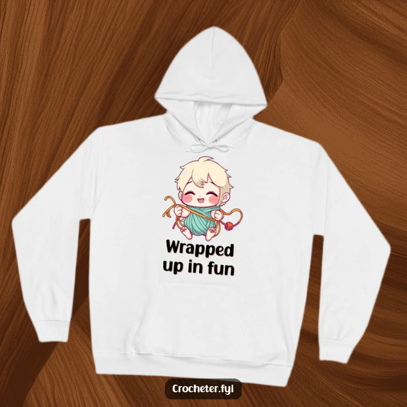 Funny Hoodie with a grinning character playfully tangled in various colorful yarn strands, perfect for cozy crafting sessions.