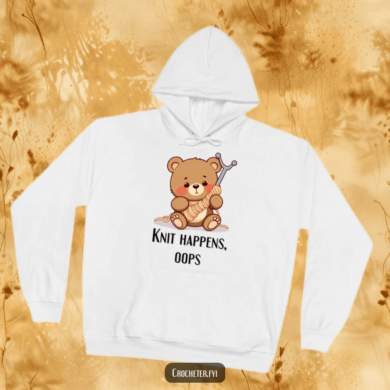 Funny hoodie depicting a clumsy bear hilariously stuck in a gigantic crochet hook, a comical knitting disaster.