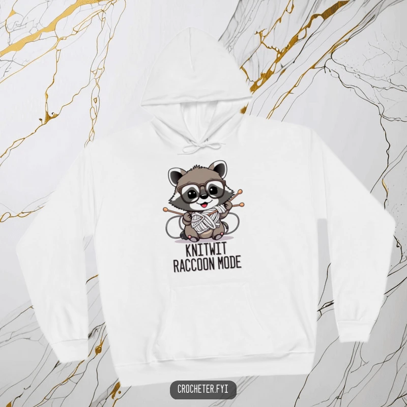 Funny hoodie depicting a mischievous raccoon wearing glasses comically entangled in knitting needles, a humorous crafting disaster.