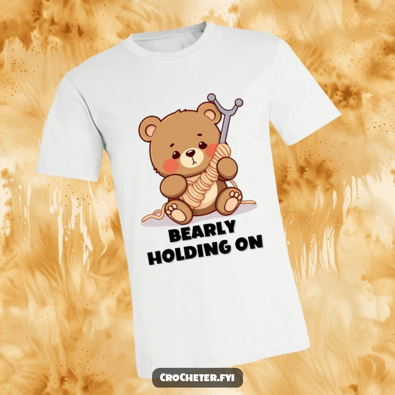 Funny t-shirt featuring a clumsy bear comically tangled in a massive crochet hook, illustrating yarn crafting mishaps.