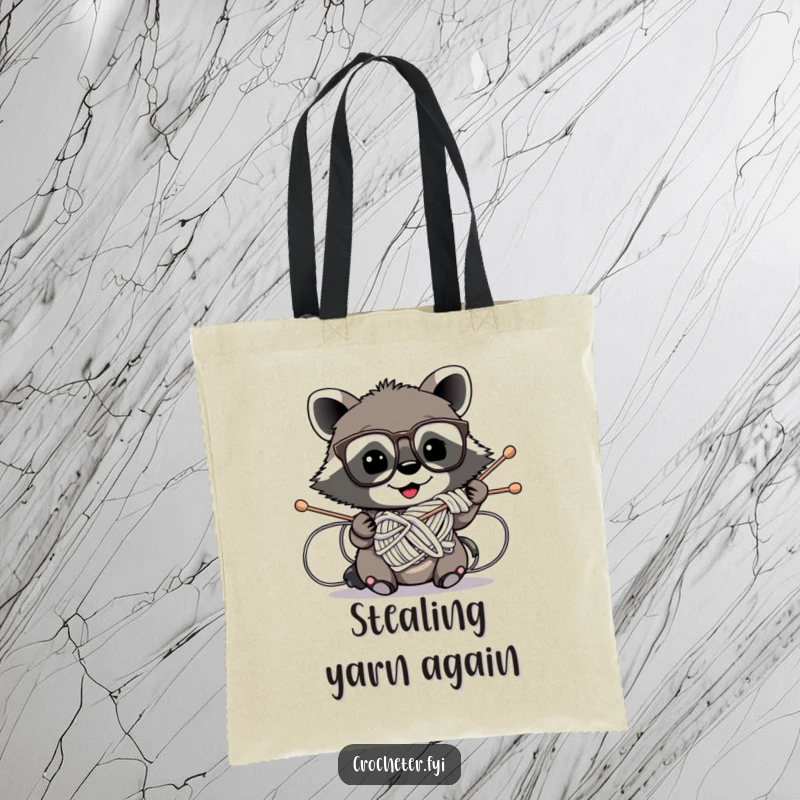 Funny tote bag with a mischievous raccoon wearing glasses hilariously tangled in knitting needles, ideal for yarn and craft supplies.